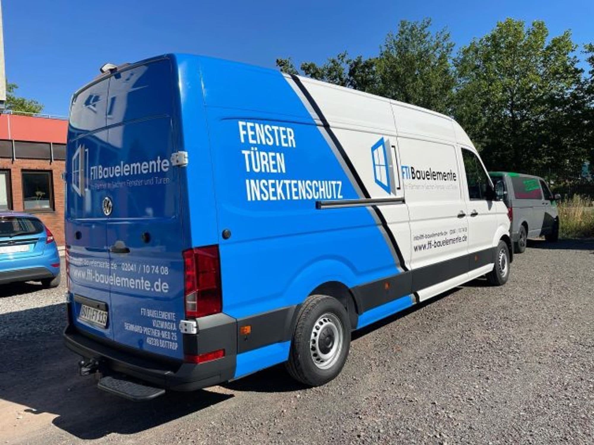 Blau-weißer Transporter mit Beschriftung von FTI Bauelemente: Fenster, Türen, Insektenschutz