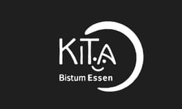 Logo: Schriftzug „KITA Bistum Essen“ in Weiß auf Schwarz, mit lächelndem Gesicht als A-Punkt und Bogen.