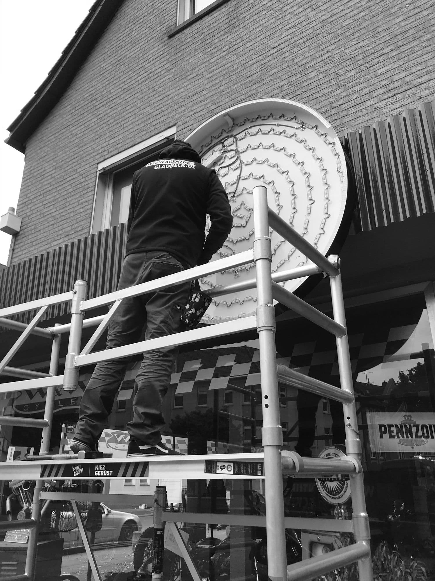 Monteur verkabelt LED-Module in einem geöffneten Leuchtkasten