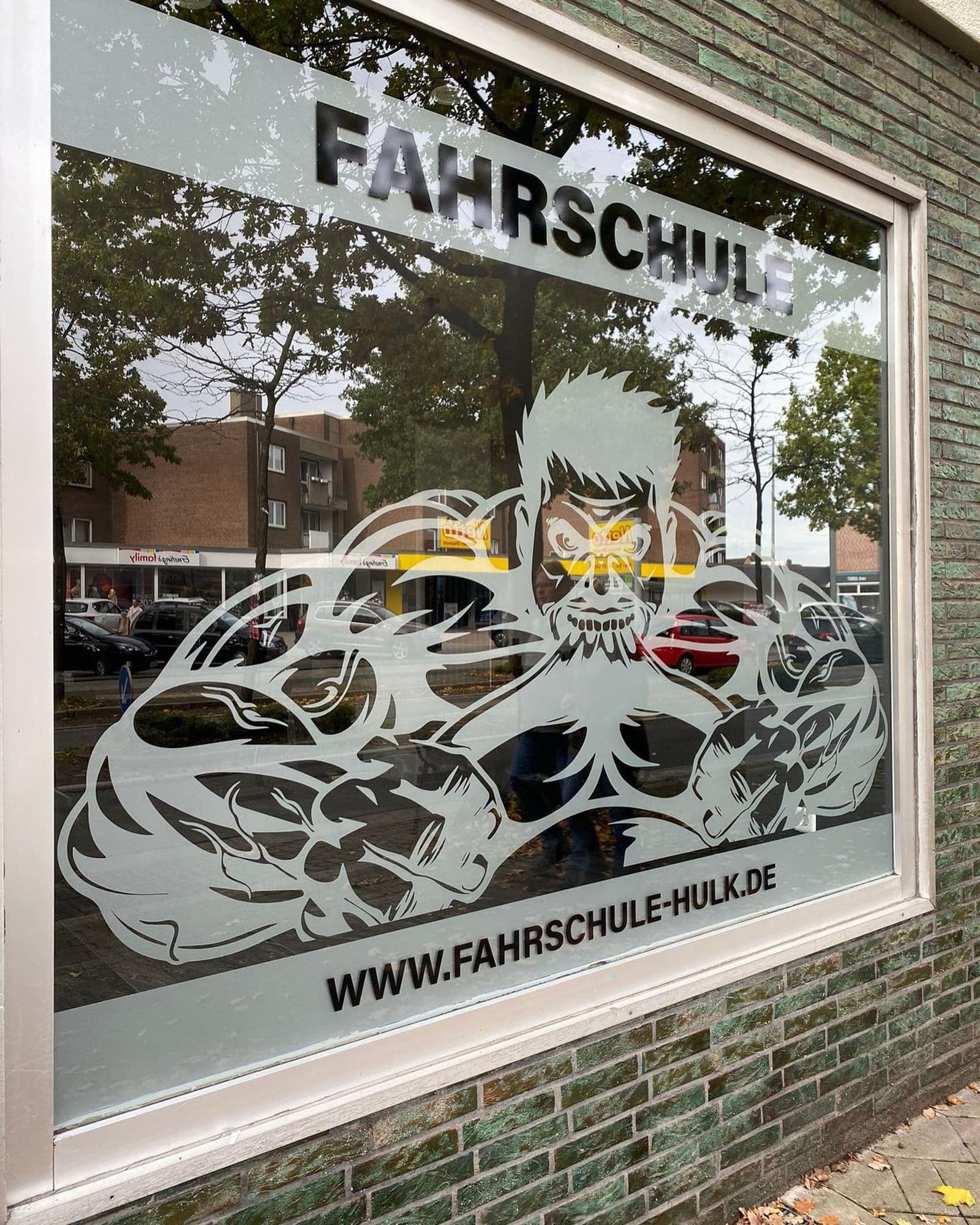 Schaufenster der Fahrschule Hulk mit großer Folienillustration und Webadresse