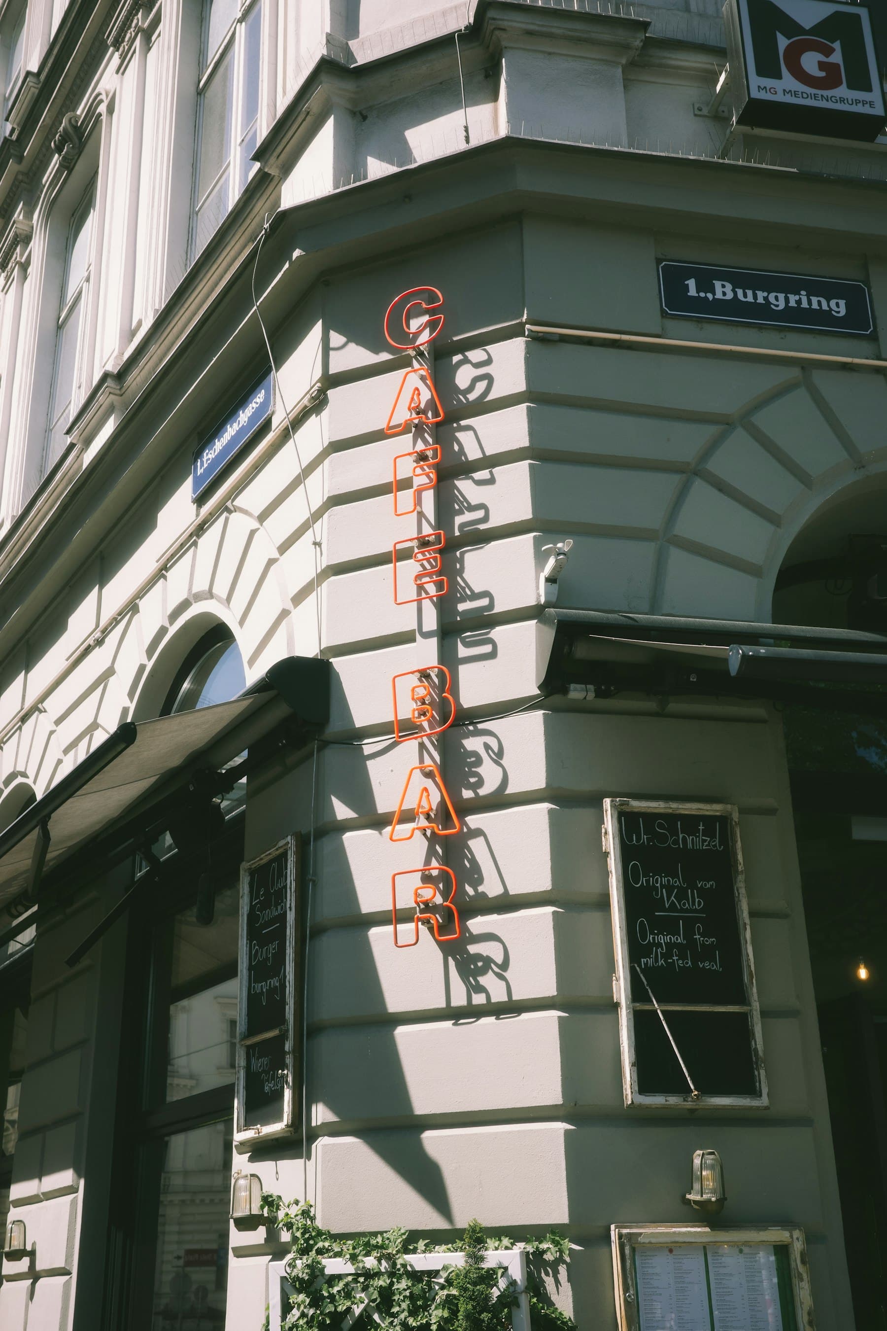 Senkrechtes Leuchtschild als Ausleger an einer Hausecke