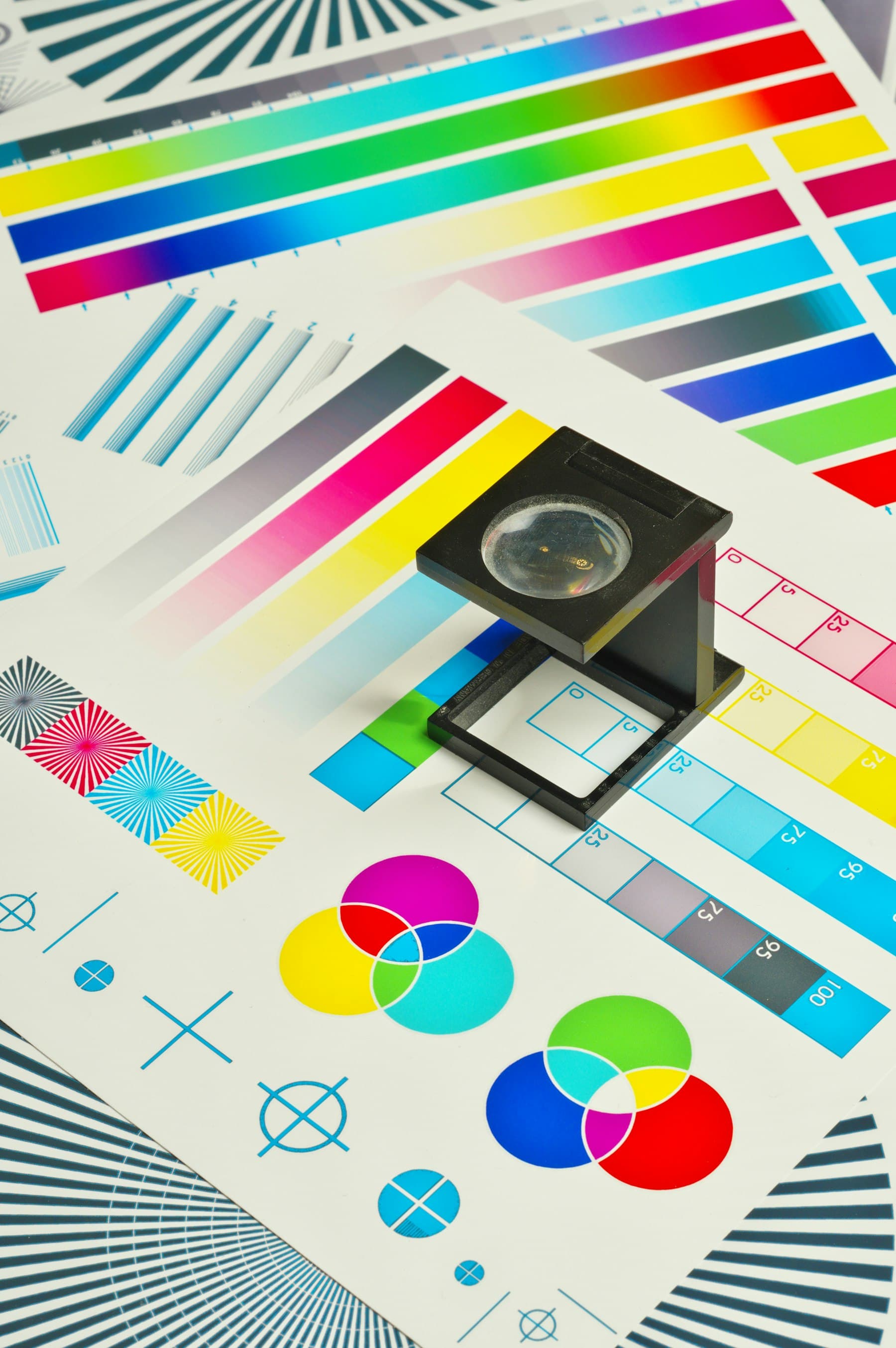 Fadenzähler auf einem Farbproof mit CMYK-Farbfeldern