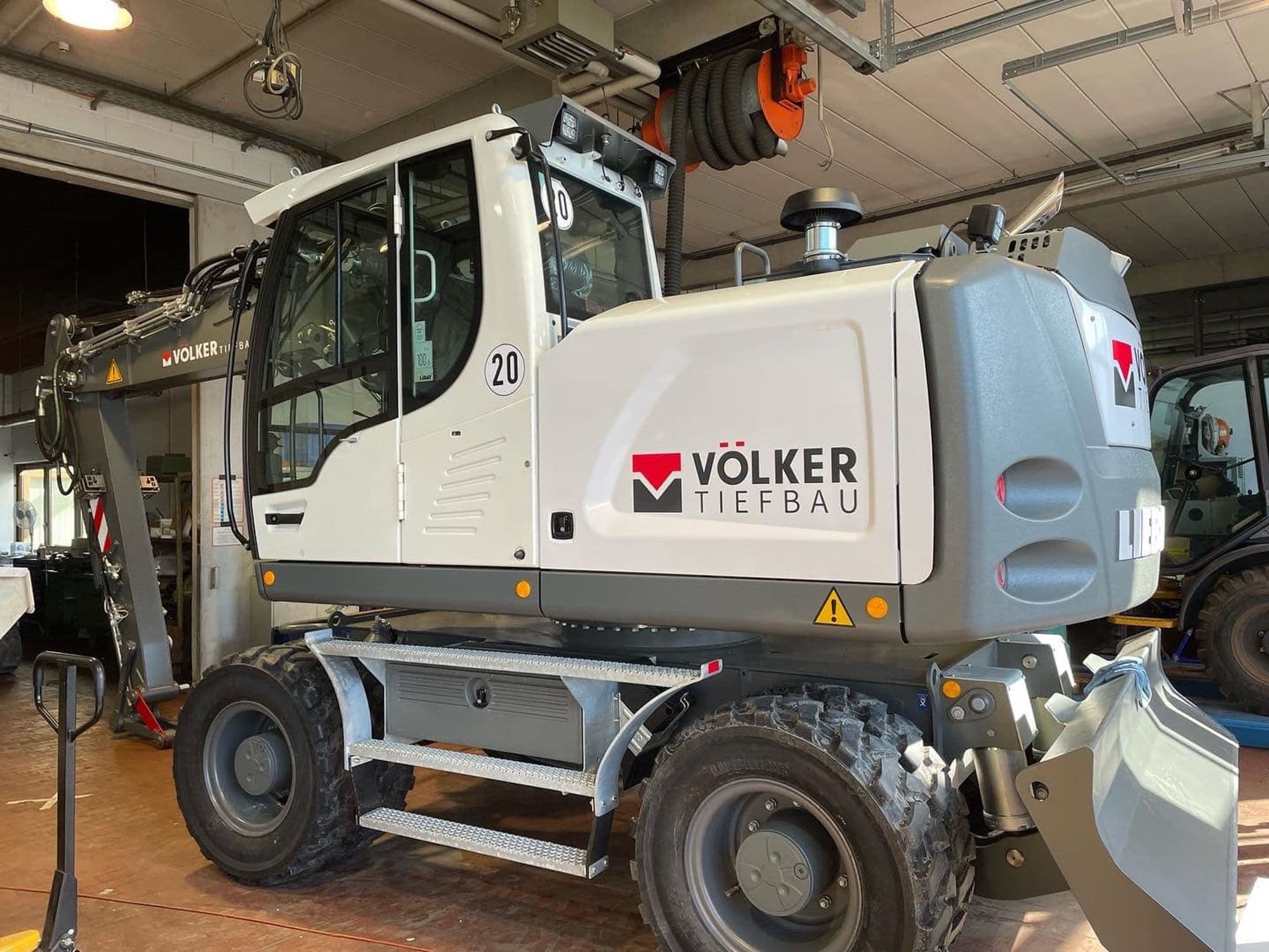 Weißer Liebherr-Mobilbagger mit Beschriftung von Völker Tiefbau
