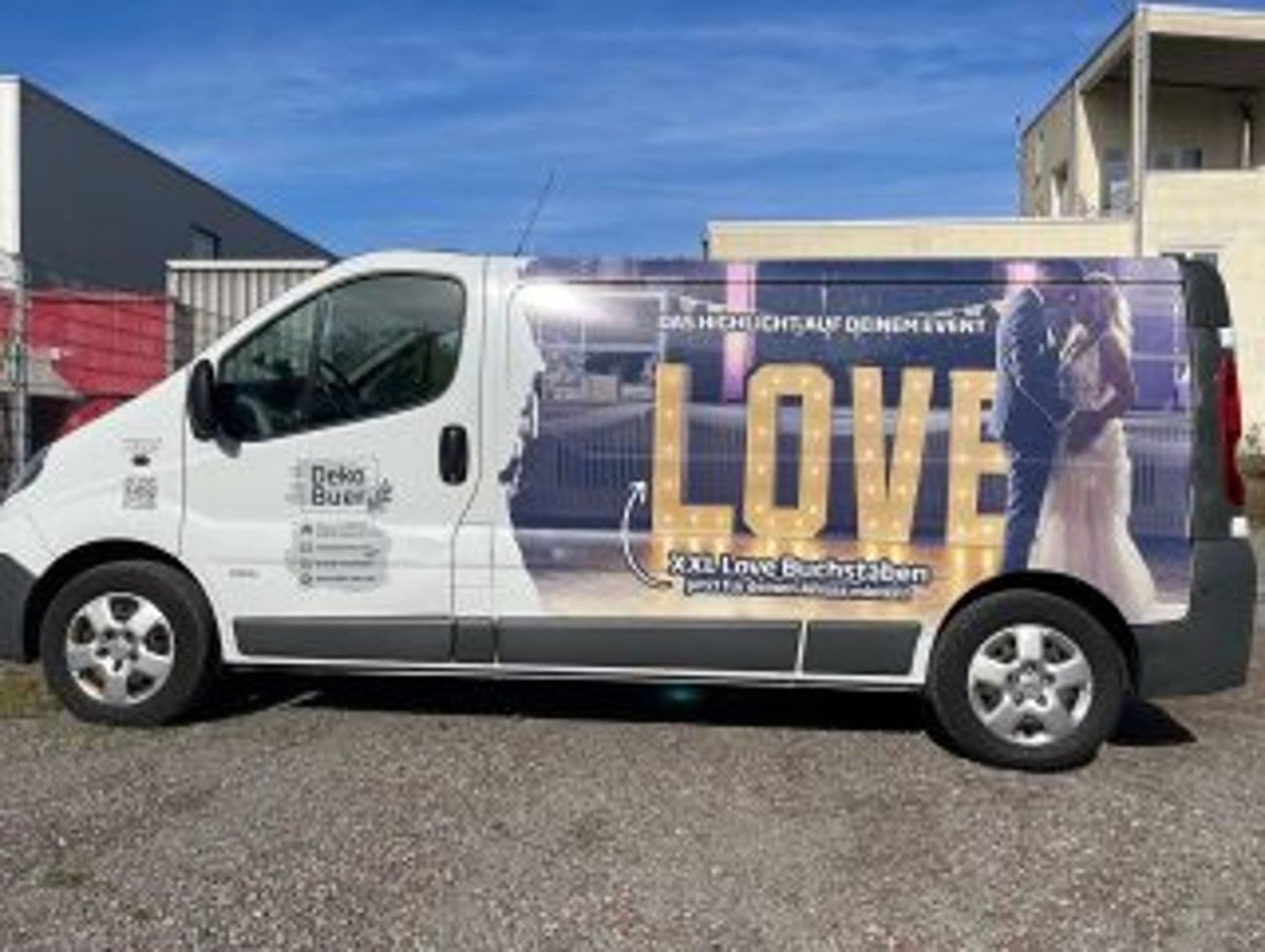 Weißer Lieferwagen mit großflächiger LOVE-Buchstaben-Werbung auf der Seite