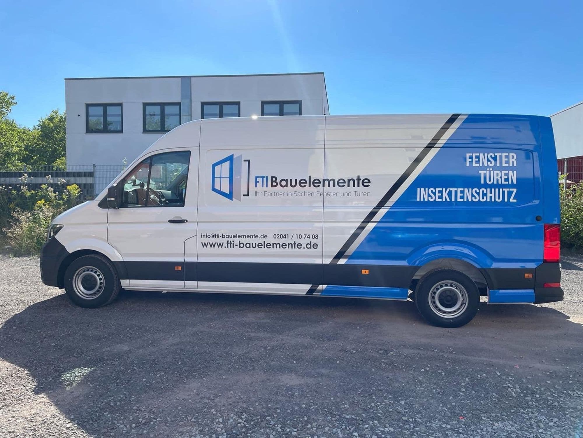Weißer Transporter mit blauem FTI Bauelemente-Logo und der Aufschrift „Fenster Türen Insektenschutz“.